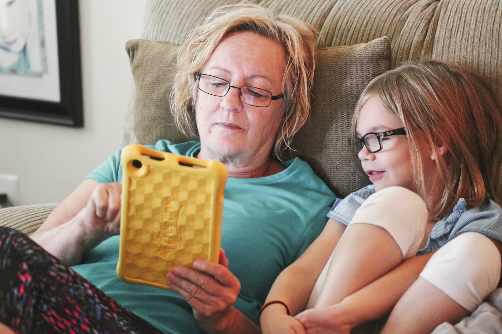 Grandmother reads to a child on an ipad