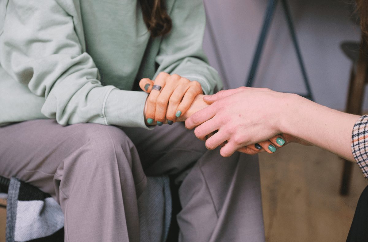 A person holding another person's hand for support